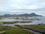 Skjærgården utenfor Andenes. Bak til høyre de forrevne klippene på vestkysten; til høyre de slake slettene på østkysten.